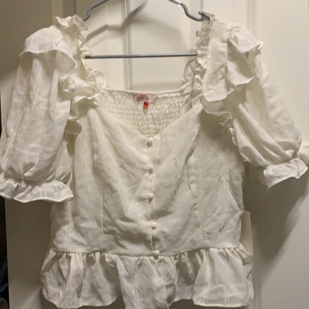 A size large cute puffy sleeved shirt. Buttons on the front.